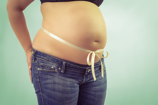 Pregnant surrogate woman belly wrapped gift ribbon.